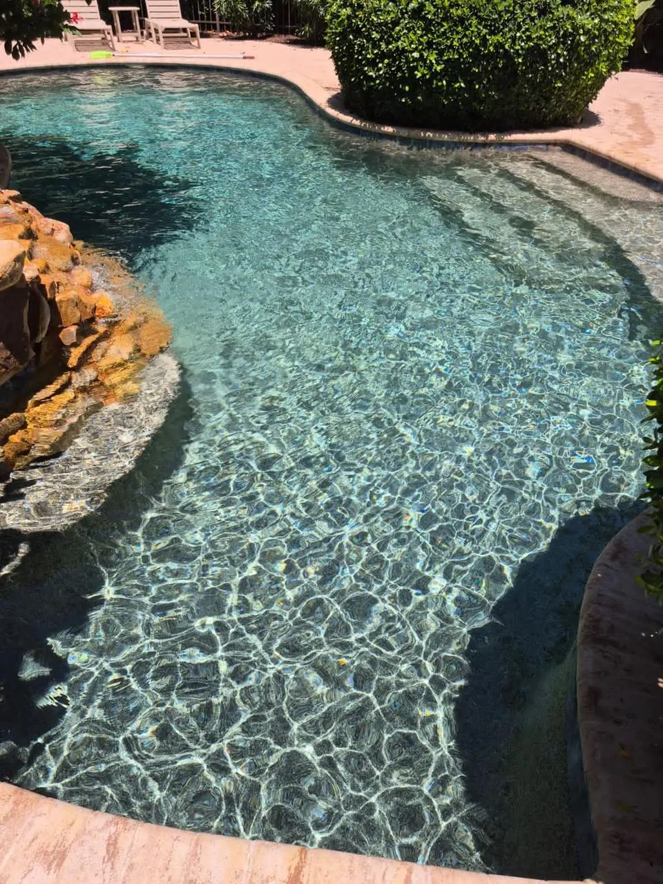 Freeform pool with rock feature and clear water